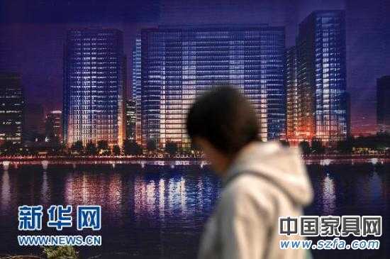 一位市民從杭州市區(qū)的一處商業(yè)樓盤廣告牌前走過（2010年11月4日攝）。新華社記者 黃宗治 攝 